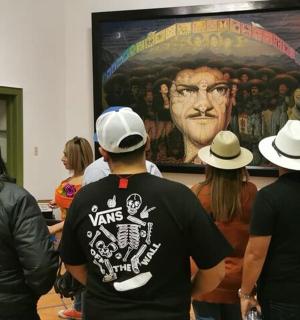 一群人站在一幅画前