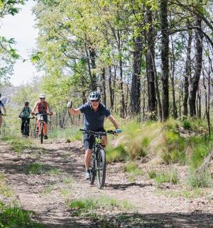 一群人骑着自行车沿着泥路行驶