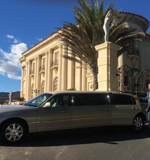 a man standing next to a limo in front of a building