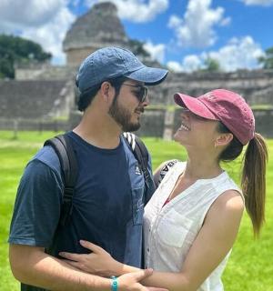 a man and a woman standing in front of a pyramid