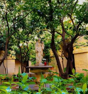 a statue of a woman on a fountain in a garden