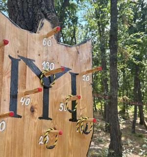a wooden clock with numbers on it next to a tree