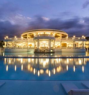 a building with a pool in front of it at night