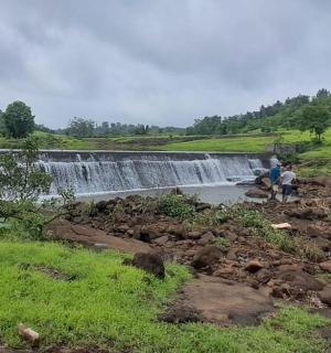 dva lidé stojící před vodopádem