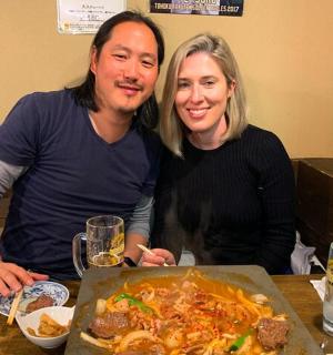 一男一女坐在桌边，面前摆着一碗食物