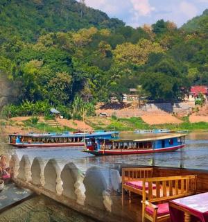 two boats on a river near a mountain