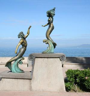 kolme merineitsi kuju ookeani lähedal seinal