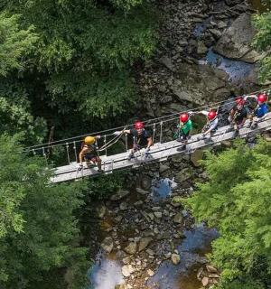 a group of people on a bridge over a river