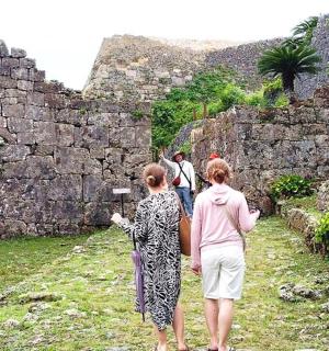 two women walking through an old stone wall