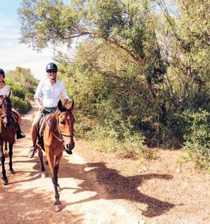 muž a žena jedoucí na koních po nezpevněné cestě