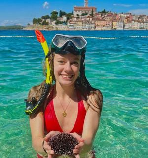 eine junge Frau im Wasser mit einer Ananas
