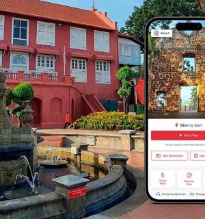 a phone taking a picture of a fountain in front of a building