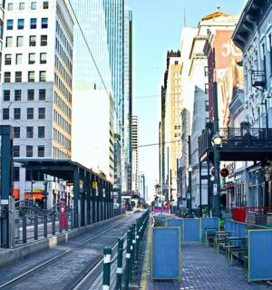 an empty city street with benches and buildings