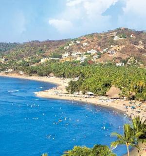 समुद्र तट पर पानी में बहुत सारे लोग