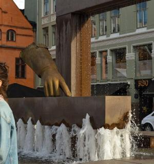 一位女士站在喷泉前