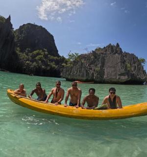 a group of men sitting on a yellow boat in the water