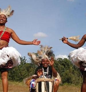a group of three women in costumes playing drums