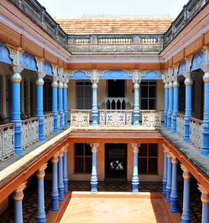 an old building with blue columns and a balcony