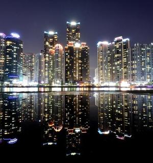 a large city at night with lights in the water