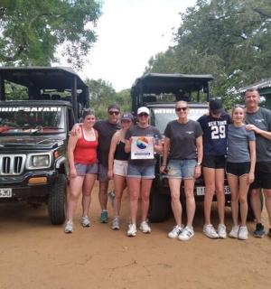 a group of people standing in front of a jeep