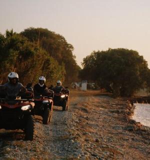 a group of people riding atvs down a dirt road