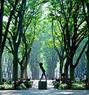 a statue of a woman in a park with trees
