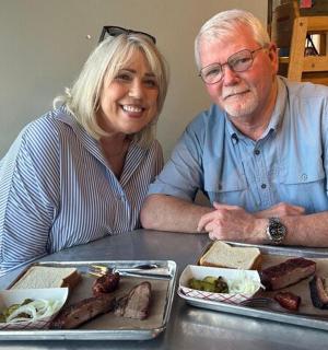 muž a žena sedící u stolu s jídlem