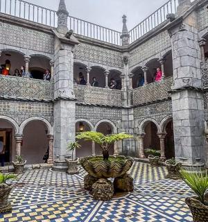 a courtyard with a large building with a plant