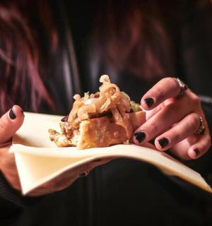 一位女士手里拿着一个盘子，盘子里放着甜点