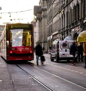 一辆红色巴士载着乘客沿着城市街道行驶