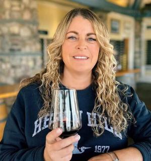 a woman holding a glass of red wine