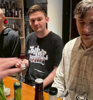 一群男人站在酒吧周围，手里拿着酒杯