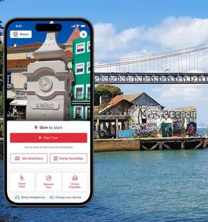 a cell phone sitting on a sidewalk next to a bridge