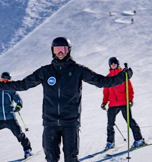 skupina lidí stojících na sjezdovce