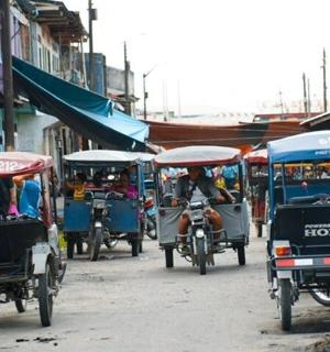 一群人在街上骑摩托车和人力车