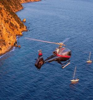 a helicopter flying over a body of water with boats