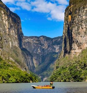 a boat in the water in front of a mountain