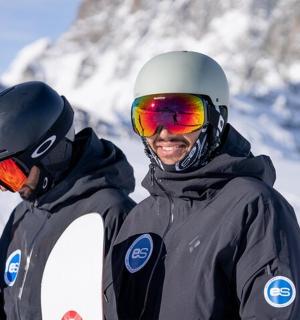 两个人拿着滑雪板站在雪地里