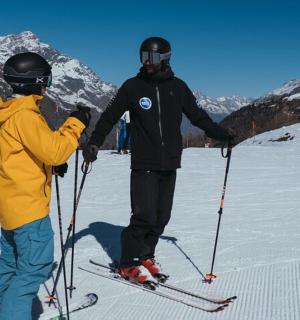 两个人站在雪地里的滑雪板上