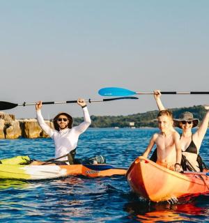 一群三人划着皮划艇在水中