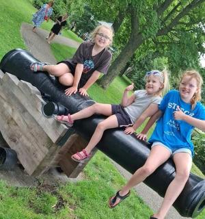 三个女孩坐在一辆假火车顶上