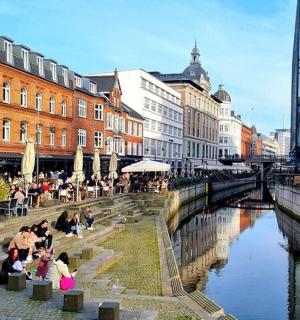 skupina lidí sedících u stolů u řeky