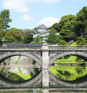 a bridge over a river with a castle in the background