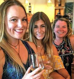 三位女士手捧酒杯摆姿势拍照