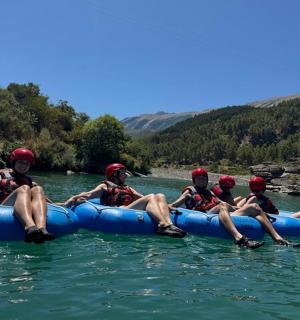 a group of people sitting on a raft in the water
