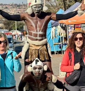 a group of people standing in front of a man in a costume