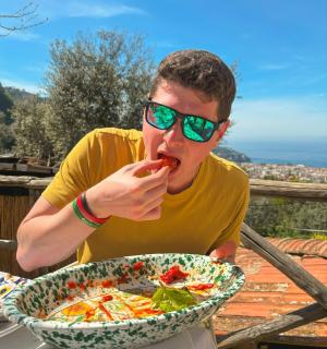 一位男士坐在桌边，手里拿着一碗食物