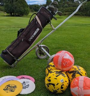高尔夫球车旁边草地上的一组球