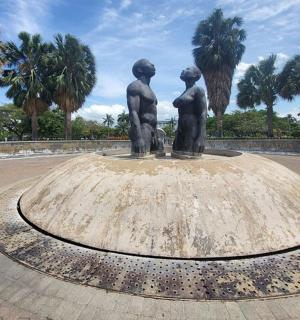 a statue of two children standing on top of a fountain
