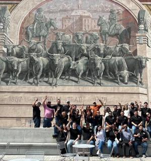 skupina lidí pózujících před sochou